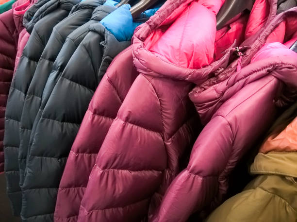 Multi colors of down jackets on the hangers at the store for sell. stock photo