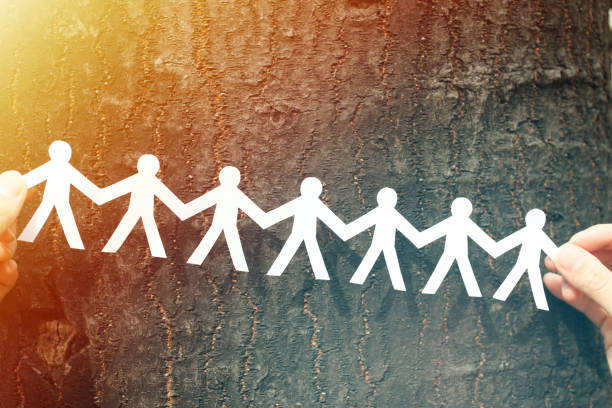 istock Hands Holding Paper Human Chain with Tree Background 1222692455