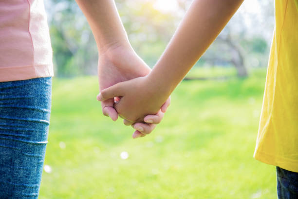 istock Two girls hand in park. 1222692692