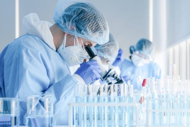 istock biochemical research scientist team working with microscope for coronavirus vaccine development in pharmaceutical research labolatory 1222693640