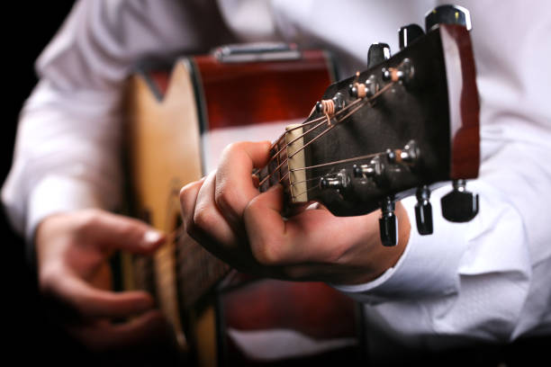 istock Young men playing the guitar with black background 1222697563