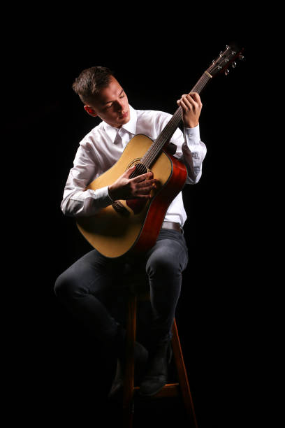 istock Young men playing the guitar with black background 1222697566