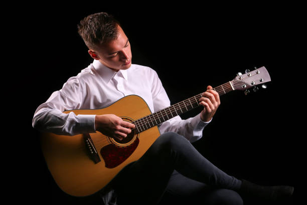 istock Young men playing the guitar with black background 1222698149
