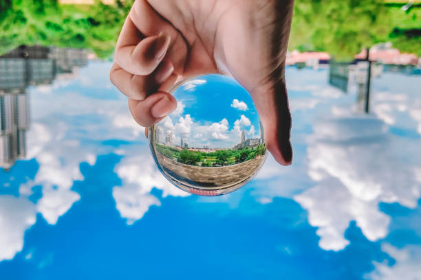 Scenery with blue sky cloud , building exterior and greed trees see through crystal ball