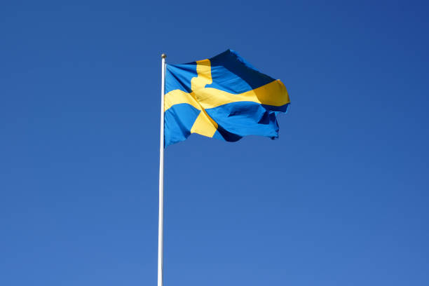 шведский флаг развевается на фоне ясного голубого неба - day sky swedish flag banner стоковые фото и изображения