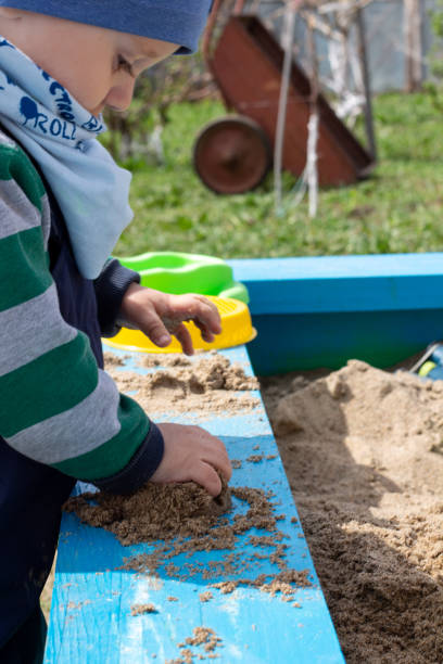 bambino gioca nella sandbox - playground cute baby blue foto e immagini stock