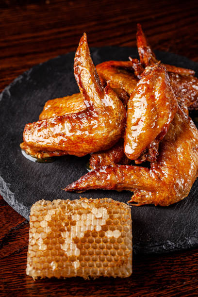 American cuisine. Fried chicken wings glazed in honey sauce on a black background. background image, copy space text