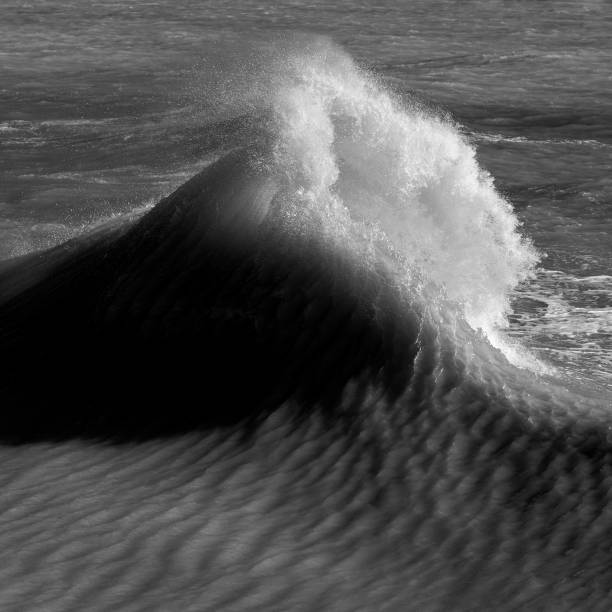 istock Amzing image of individual wave breaking and cresting during violent windy storm in black and white with superb detail 1222716184