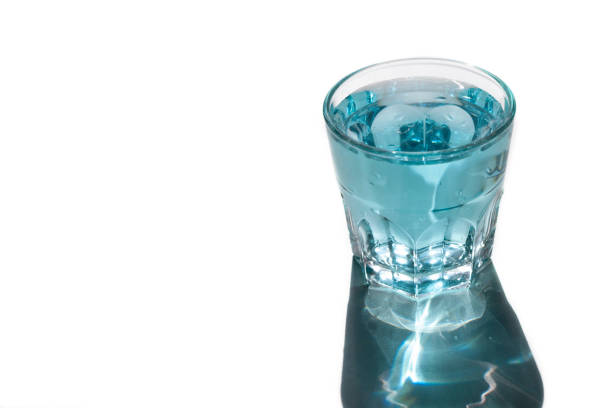 glass with blue water, bright shadow. Refreshing drink. Copy space.