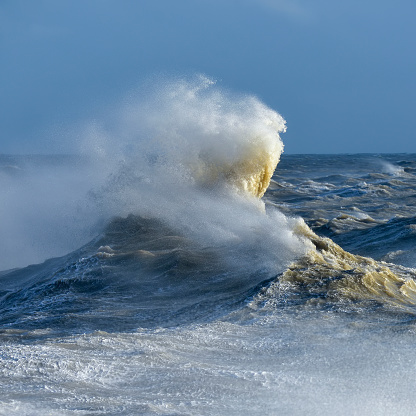 Stunning image of individual wave breaking and cresting during violent windy storm with superb wave detail