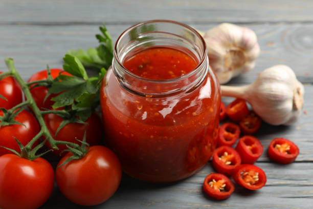istock Jar with red chilli and tomato sauce, and spices on wooden table 1222722232
