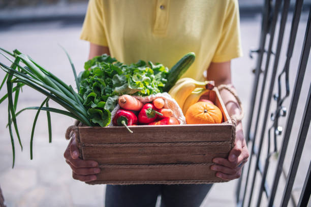 istock Woman With Protective Face Mask Delivering Vegetables During Quarantine 1222724116