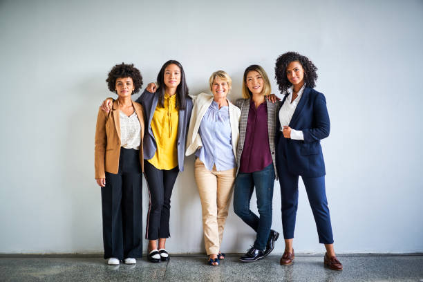 Confident multi-ethnic businesswomen at office Portrait of confident female professionals. Smiling multi-ethnic businesswomen standing together. They are against wall at office. preppy fashion stock pictures, royalty-free photos & images