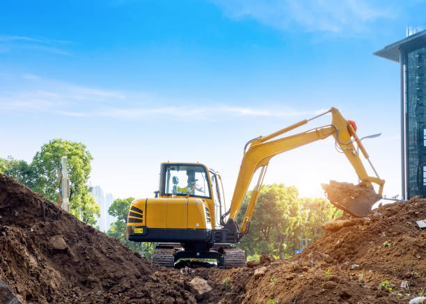 excavadoras excavan tierra en el sitio de construcción - earth mover digging land bulldozer fotografías e imágenes de stock