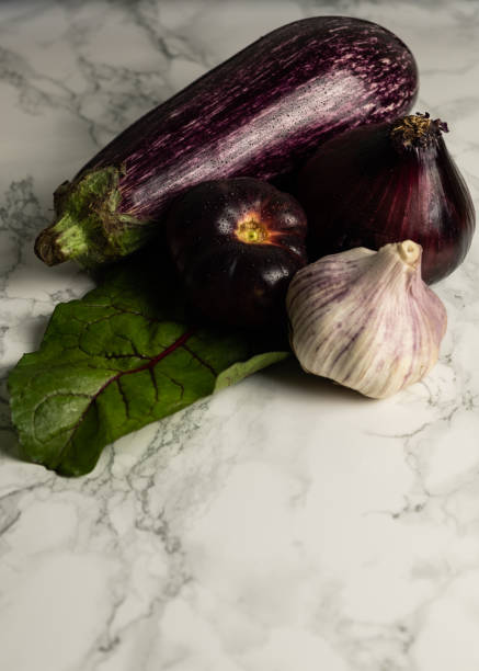 istock purple eggplant, garlic, purple onion on white marble background 1222730137