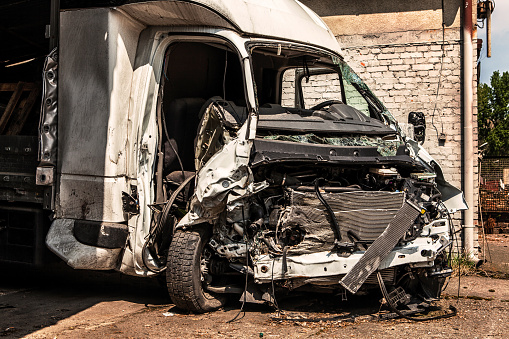 Destroyed white van after a frontal collision