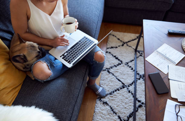 istock Anonymous young female working on sofa with pet dog 1222732066