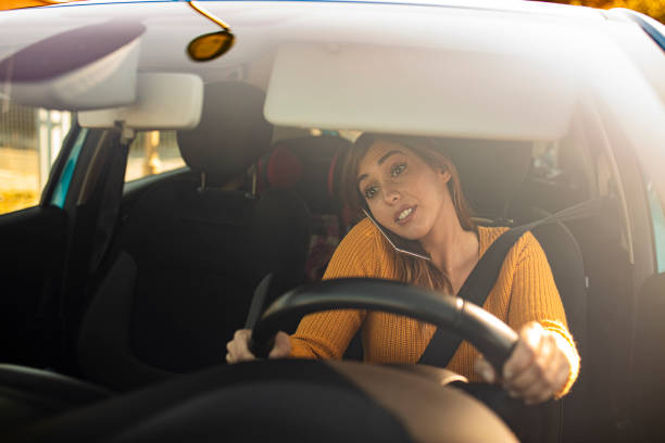 istock Woman driving car and using smart phone 1222733832