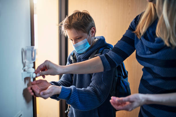 Little boy disinfecting hands after returning from school