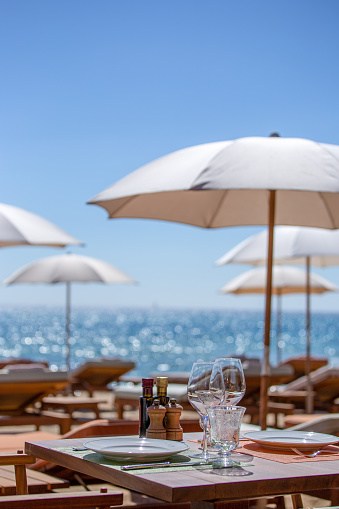 Beach restaurant on the French Riviera in summer. The sky is blue, the weather is nice and warm. It's the holidays.