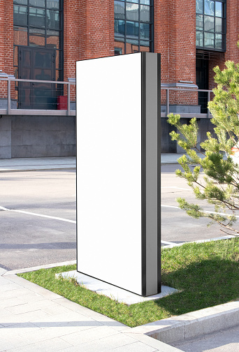 Blank white vertical pylon stand mockup brick building, side view. Empty information stand on street for advertise mock up. Clear vertical monitor or totem for affiche or ad mokcup template.