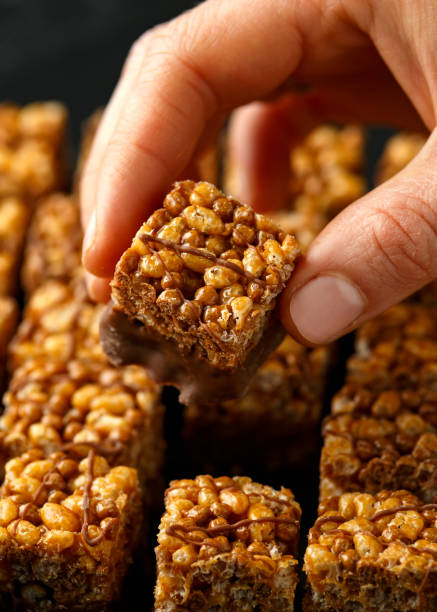 istock Crispy rice bar, snack with caramel and chocolate on rustic background 1222740945