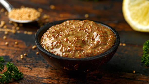 istock whole grain mustard in bowl on wooden table. 1222740986