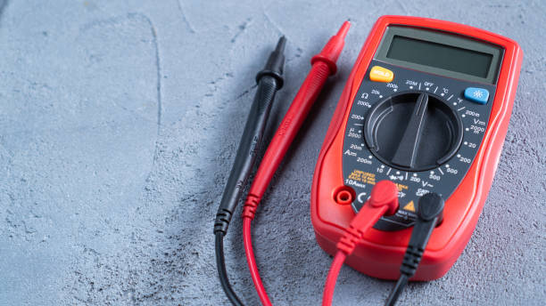 istock Red multimeter or a multitester, also known as a VOM on gray table. Electronic measuring instrument. Red and black wires 1222741010