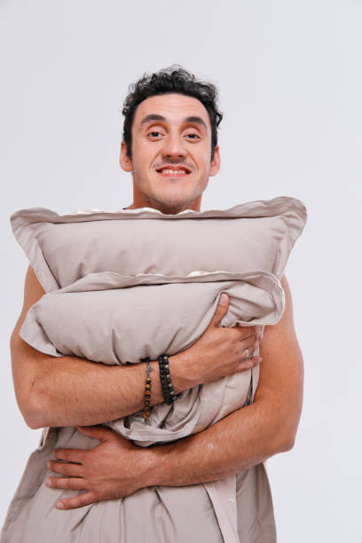 istock Studio portrait of sleepy man holding pillows 1222743754