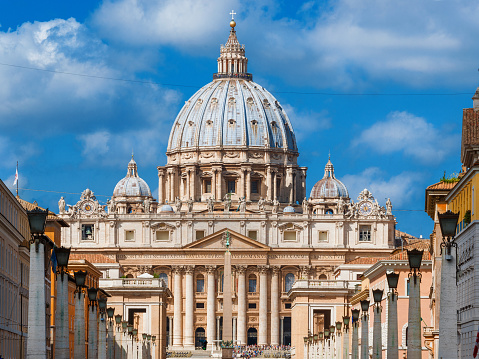 Rome, Italy - September 3, 2015: View of the beautiful Saint Peter Basilica, center of Catholicism and a famous city landmark, from Via della Conciliazione (Road of the Conciliation) in Rome