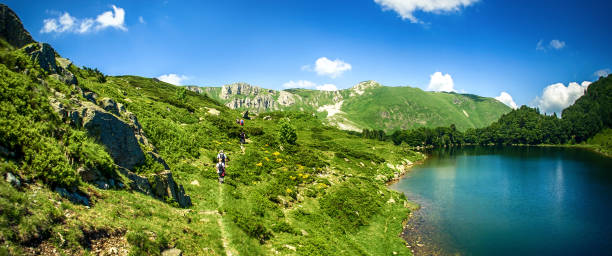 vista panoramica della bellissima catena montuosa con lago cristallino - clear sky panoramic grass scenics foto e immagini stock