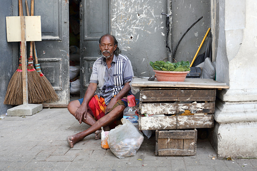 Kandy, Sri Lanka - February 9, 2020: Poor man sells betel leaves on the street in Kandy