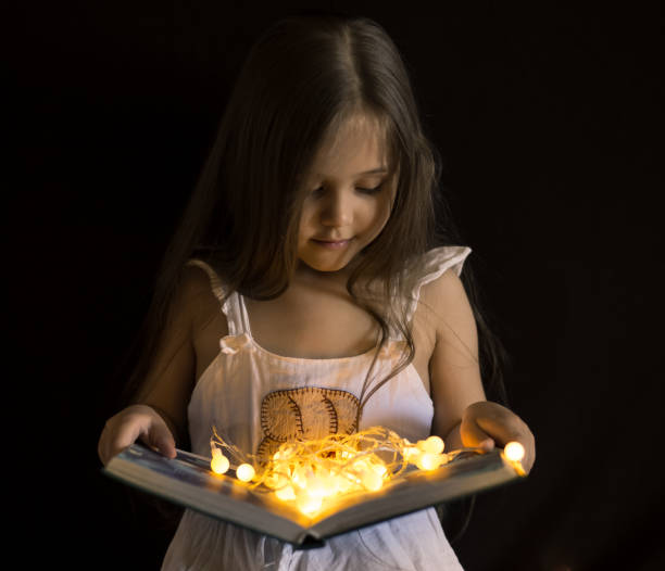 istock little girl is reading a magic book 1222748012