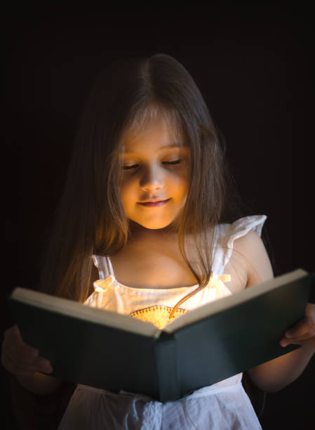 istock little girl is reading a magic book 1222748182