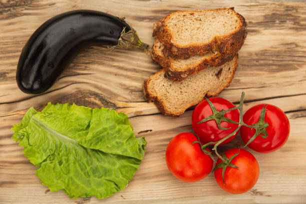 tomatoes, lettuce, bread and eggplant on a wooden Board