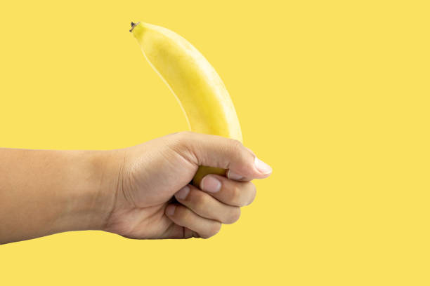 istock hand holding Banana isolated on white background 1222750186