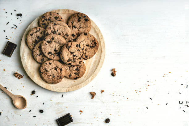 plato de galletas artesanales con chips de chocolate sobre un fondo blanco - chocolate chip cookie cookie chocolate stack fotografías e imágenes de stock