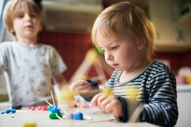 istock Two brothers make three-dimensional figures of plasticine and sticks 1222750609