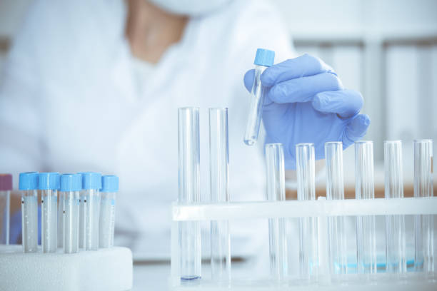 istock Professional female scientist in protective eyeglasses and mask making experiment with reagents in laboratory. Coronavirus pandemic stop. Medicine concept 1222751539
