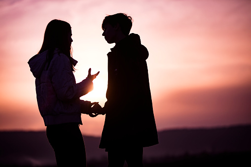 Teen Boyfriend and Girlfriend Talking Outdoors.