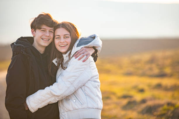 Portrait of Smiling Late Teen Couple Hugging Outdoors stock photo