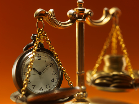 Golden scales of justice  with pocket watch and stack of gold coin time is money concept