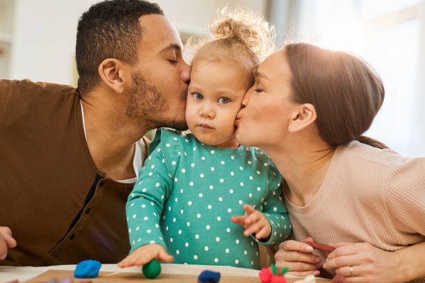 istock Parents Kissing Little Daughter 1222756265