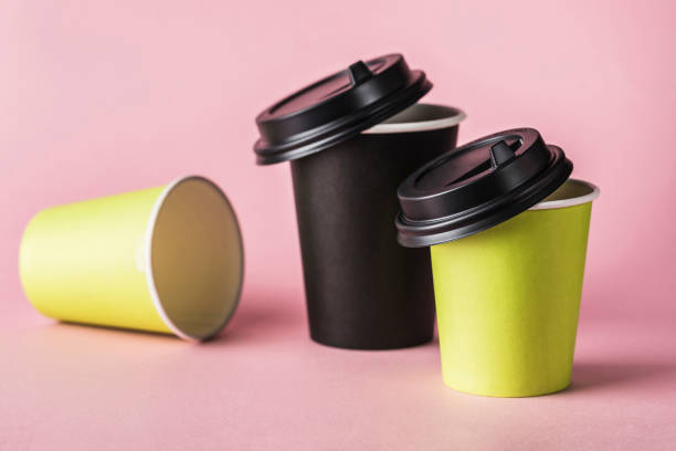istock Some green and black paper reusable coffee cups with lids on a pink background. 1222756327