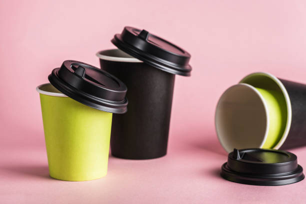 istock Some green and black paper reusable coffee cups with lids on a pink background. 1222756597