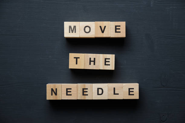 istock Modern business buzzword - move the needle. Top view on wooden table with blocks. Top view. 1222759528