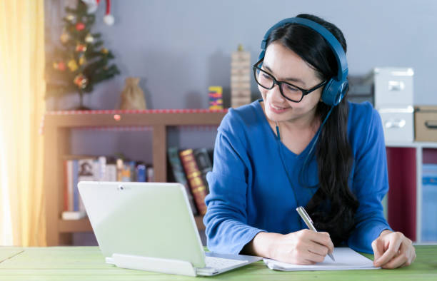 Female writing for studying online or tutor at home. stock photo