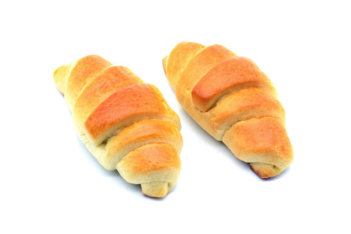 two fresh buttery croissant. White isolated background.