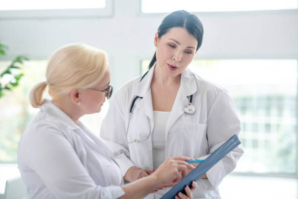 istock Two female doctors reading the medical history and looking interested 1222763228
