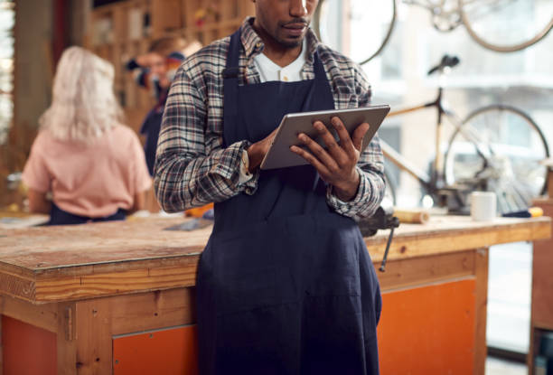 istock Close Up Of Male Craftsman In Carpentry Workshop For Bamboo Bicycles Using Digital Tablet 1222763415